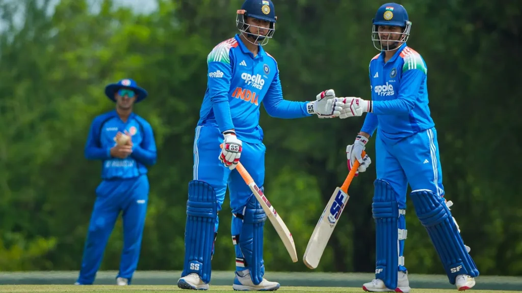 Vaibhav Sooryavanshi fist-bumps his batting partner mid-pitch during an India A innings, with an Afghanistan fielder in the background